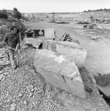 Kalksteinbruch bei Anröchte, August 1975: Steinhauer oder Steinmetz bei der Zurichtung von Steinblöcken.