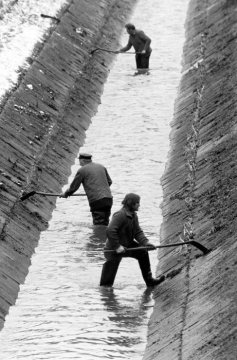 Städtische Bedienstete bei der Säuberung der Kanalwände des Landwehrbachs, Nebengewässer der Emscher bei Castrop-Rauxel, in Funktion als Schmutzwasserkanal. Februar 1987.