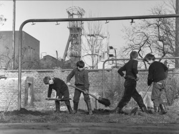 Jungen bei Grabearbeiten auf dem Trockenplatz. Im Hintergrund: Zeche Graf Moltke Schacht 2, Gladbeck. Undatiert.