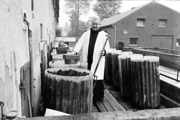 Benediktiner-Bruder der Abtei Gerleve bei der Pflege seiner Regenwurmzucht auf dem Wirtschaftshof des Klosters. Billerbeck, 1974.