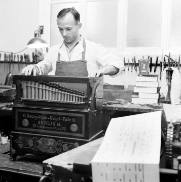Orgelbauer Max Alfred Geweke bei der Reparatur einer Drehorgel des Berliner Herstellers Bacigalupo in seiner Werkstatt in Bielefeld, gegründet 1900 von Großvater Albert Geweke und fortgeführt von Vater Max,1966.