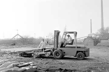 Auf einem Abbruchgelände im Ruhrgebiet: Fotograf Helmut Orwat (im Gabelstapler) bei der Bergung von Altmetall zur Unterstützung von Hilfsprojekten des Paters Erwin Immekus von der russischen Gemeinde Datteln-Horneburg. März 1976.