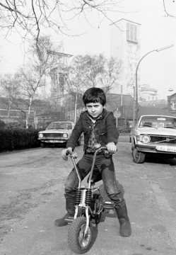 Junge mit Fahrrad auf dem Parkplatz am Werkstor einer Zeche. Motiv und Standort unbezeichnet. Undatiert, 1980er Jahre?