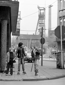 Kinder mit Hockeyschlägern - im Hintergrund: Förderturm von Zeche Erin, Ansicht aus Richtung Widumer Straße. Castrop-Rauxel, April 1980.