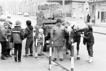 Gruppe von Kindern mit einer älteren Frau mit Pferdefuhrwerk, mit Stroh beladen, Bochum, im April 1986.