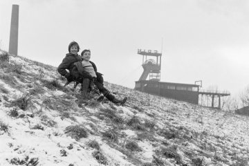 Winter, Schnee im Januar 1980: Rodelvergnügen in Castrop-Rauxel. Im Hintergrund: Förderturm von Zeche Erin.