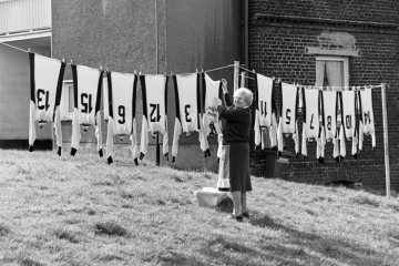 Hausfrau beim Wäschemachen auf einem Trockenplatz in Castrop-Rauxel-Dingen, April 1982. Auf der Wäscheleine trocknen Fußballtrikots. 