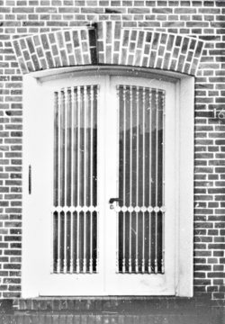 Zweiflügelige Haustür mit Glasfenstern und Metallgitter, Münster. Undatiert.