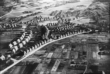 Neubausiedlungen aus Mehrfamilien- und Einfamilienhäusern, im Vordergrund: Würfelhäuser entlang einer Straßenachse. Standort unklar, zugeschrieben Herford oder Münster, 1939-1945.
