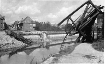 Kriegsschäden in Münster 1945: Dortmund-Ems-Kanal mit zerstörter Brücke an der Schillerstraße; mittig im Bild Eckhaus Lambertistraße 47