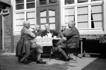Ernst Wenzel (1890-1974, zweiter von links), Amateurfotograf und Lehrer an der Geistschule und der Volksschule Mecklenbeck in Münster, hier in einer Kaffeewirtschaft während eines Ausflugs mit Lehrerkollegen. Undatiert, vor 1945.