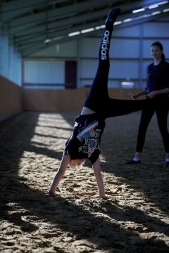 Voltigieren - Akrobatik zu Pferde: Voltigiergruppe beim Aufwärmübungen vor dem Training. Lemgo, 2019.