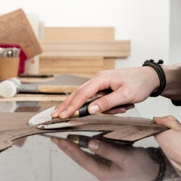 Anfertigung eines Sattels: Die Lederteile werden anhand der Pappmuster mit einem Halbmondmesser zugeschnitten. Hofsattlerei Cosack, Arnsberg, Januar 2018.