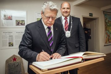 Bundespräsident Gauck trägt sich in das Goldene Buch der Stadt Schloß Holte-Stukenbrock ein; rechts: Hubert Erichlandwehr (CDU, Bürgermeister Schloß Holte-Stukenbrock)