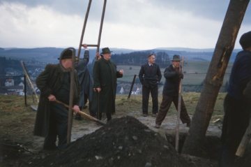 Osterfeuerbrauch in Attendorn: "Poskebrüder" des Osterfeuervereins beim Aufrichten eines Osterkreuzes mittels langer Stangen