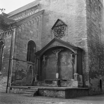 Die Kirche St. Johannes der Täufer: Kreuzigungsgruppe und Uhr an der Nordseite des Turms