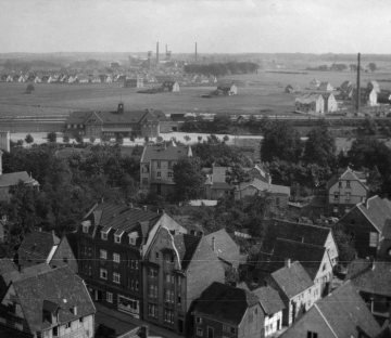 Blick über die Stadt Ahlen in südöstliche Richtung, an der Bahnstrecke mit Uhrenturm auf dem Dach das Bahnhofsgebäude