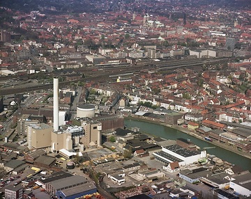 Münster, Hafen: Kanalhafen, Dortmund-Ems-Kanal, Kohle-Heizkraftwerk (errichtet 1977, 2005 auf Gas umgestellt), Bahntrasse und Hauptbahnhof, dahinter das Stadtzentrum