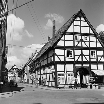 Rinteln-Altstadt, 1961: Haus Kirchplatz Nr. 8 mit Feinkosthandel Sasse (Ansicht von Südosten), links die Kreuzstraße mit den Fronten der Häuserzeile Kirchplatz Nr. 7-1, im Hintergrund: Haus Bäckerstraße Nr. 1