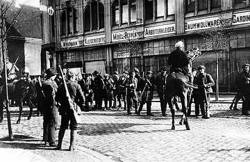 Weimarer Republik: Truppen der Roten Ruhrarmee sammeln sich in Lohberg (heute Dinslaken-Lohberg), im Hintergrund das jüdische Kaufhaus S. Bernhard, links Teilansicht der Synagoge. März 1920.