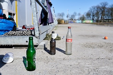 Winternothilfe Münster: Leere Flaschen auf dem Boden vor einem der Container.