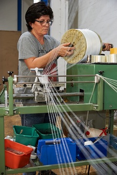 Greven, Firma SETEX-Textil GmbH: In der Glasfaser-Weberei, Frau Maria da Silva spult Glasfaser-Garne auf.