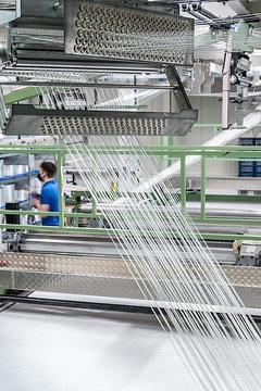 Saerbeck, Saertex GmbH & Co. KG: Die Firma produziert textile multiaxiale Gelege aus Glas-, Carbon- und Aramid-Fasern, diese dienen als Verbundstoffe im Leichtbau für Windenergie, Luft- und Schifffahrt, die Automobil- und Bauindustrie, Blick in die Produktion, an der Multiaxialgelegemaschine, hier entstehen die textilen Gelegebahnen.