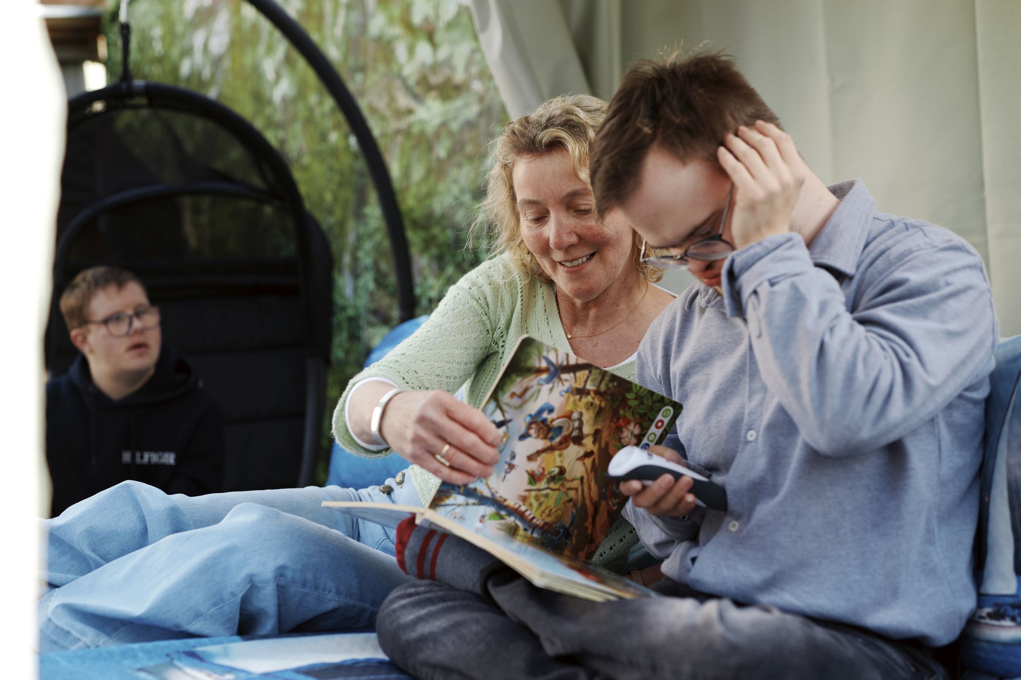 Die Pflegefamilie ist gerne draußen, deshalb hat Wally Böing für die Mittagspause ein großes Bett im Freien aufgestellt, das sie hier gerade mit Julien (r.) nutzt.<br>Foto: LWL/Nikolaus Urban