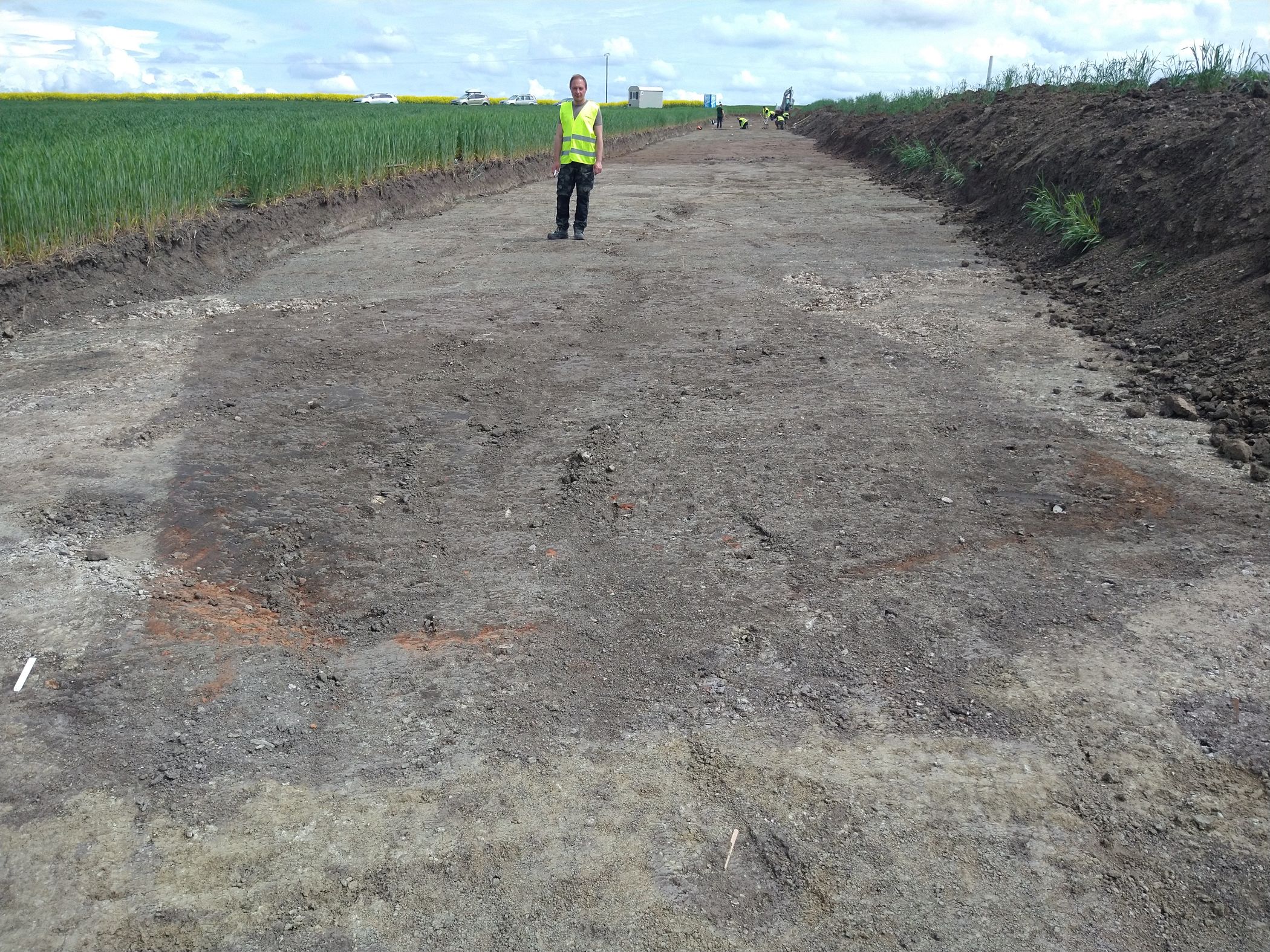 Grabungsleiter Bartosz Adamski steht vor einer mittelalterlichen Kellergrube.<br>Foto: LWL-Archäologie/S. Spiong