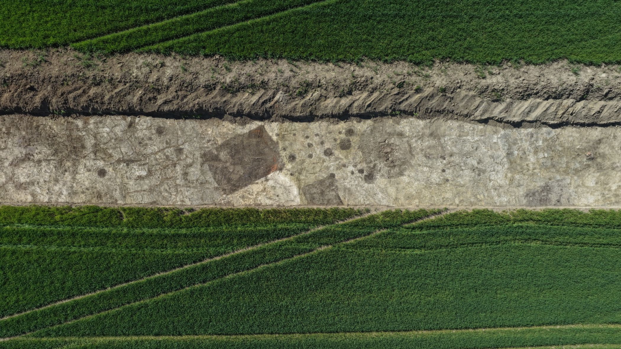 Im Drohnenbild werden die Kellergrube und der Brunnen mit runder Baugrube rechts daneben sehr deutlich.<br>Foto: LWL-Archäologie/A. Koch