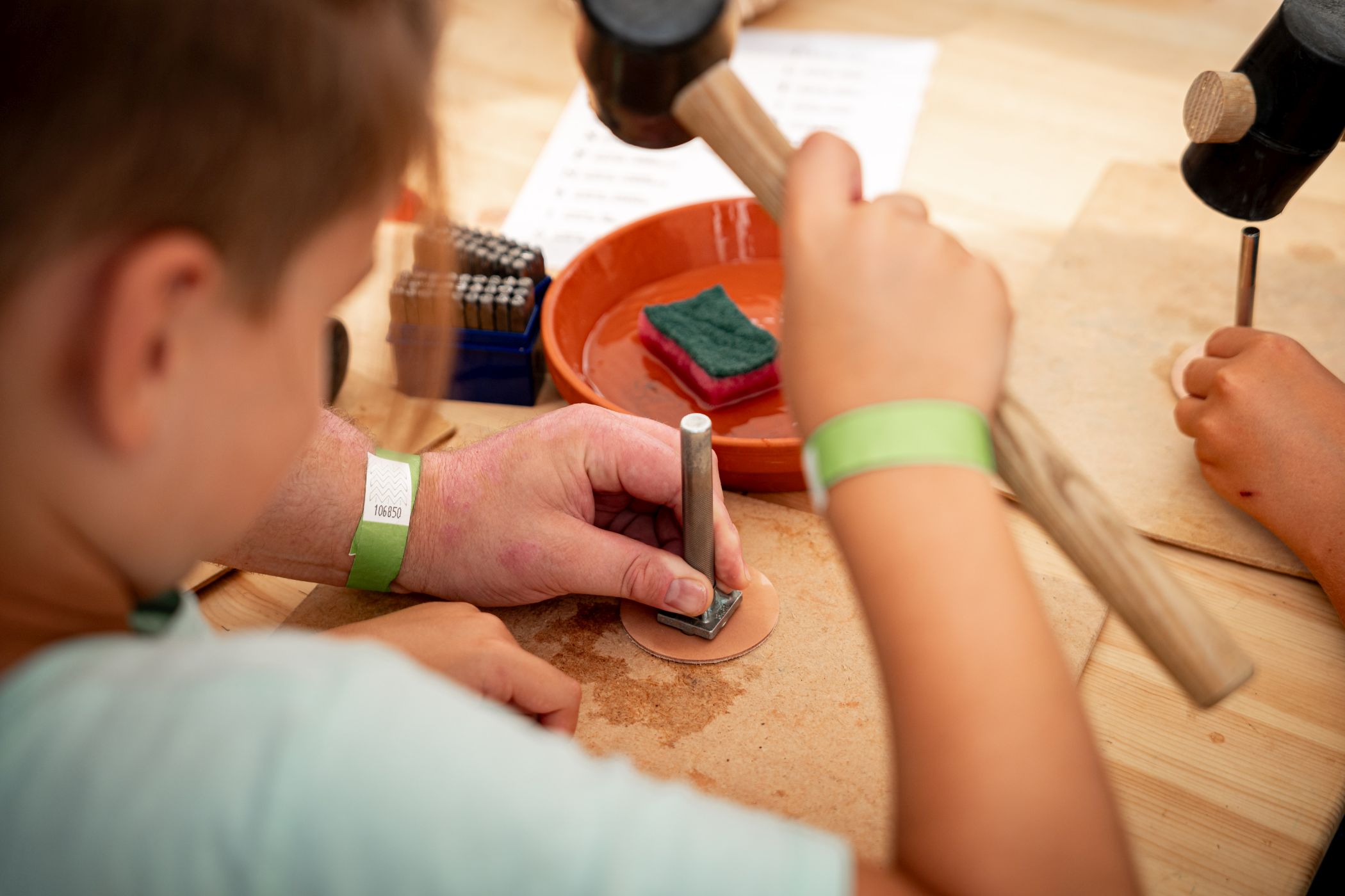 Kinder können ihre eigenen Lederanhänger prägen, wahlweise mit  römischen oder germanischen Motiven.<br>Foto: LWL/D. Stock
