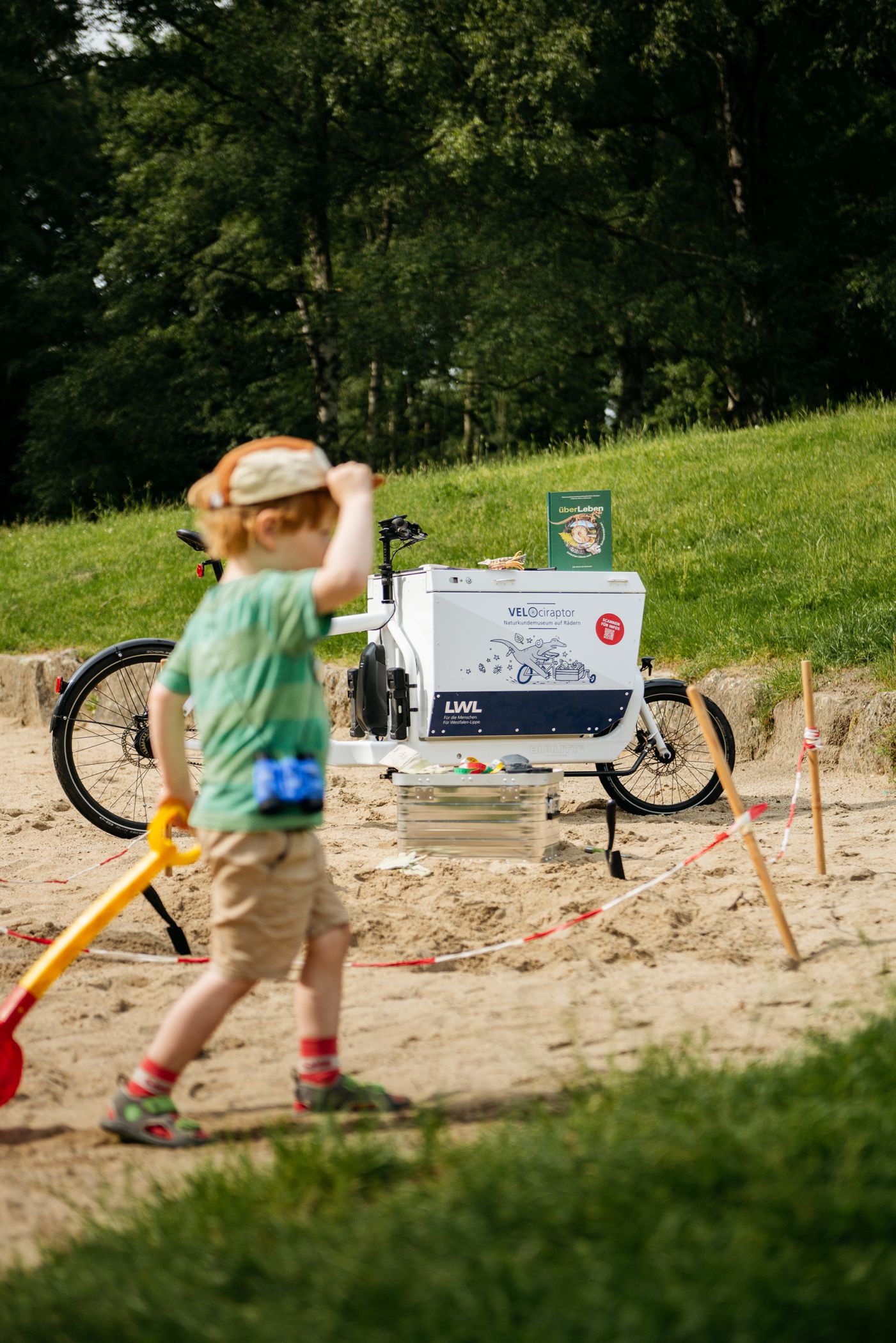 Das Museum auf Rädern, der VELOciraptor, geht auf Saurier-Spielplatztour. Auf verschiedenen Spielplätzen in Münster können Kinder in die Rolle von Paläontolog:innen schlüpfen und eigene Funde freilegen.<br>Foto: LWL/Steinweg