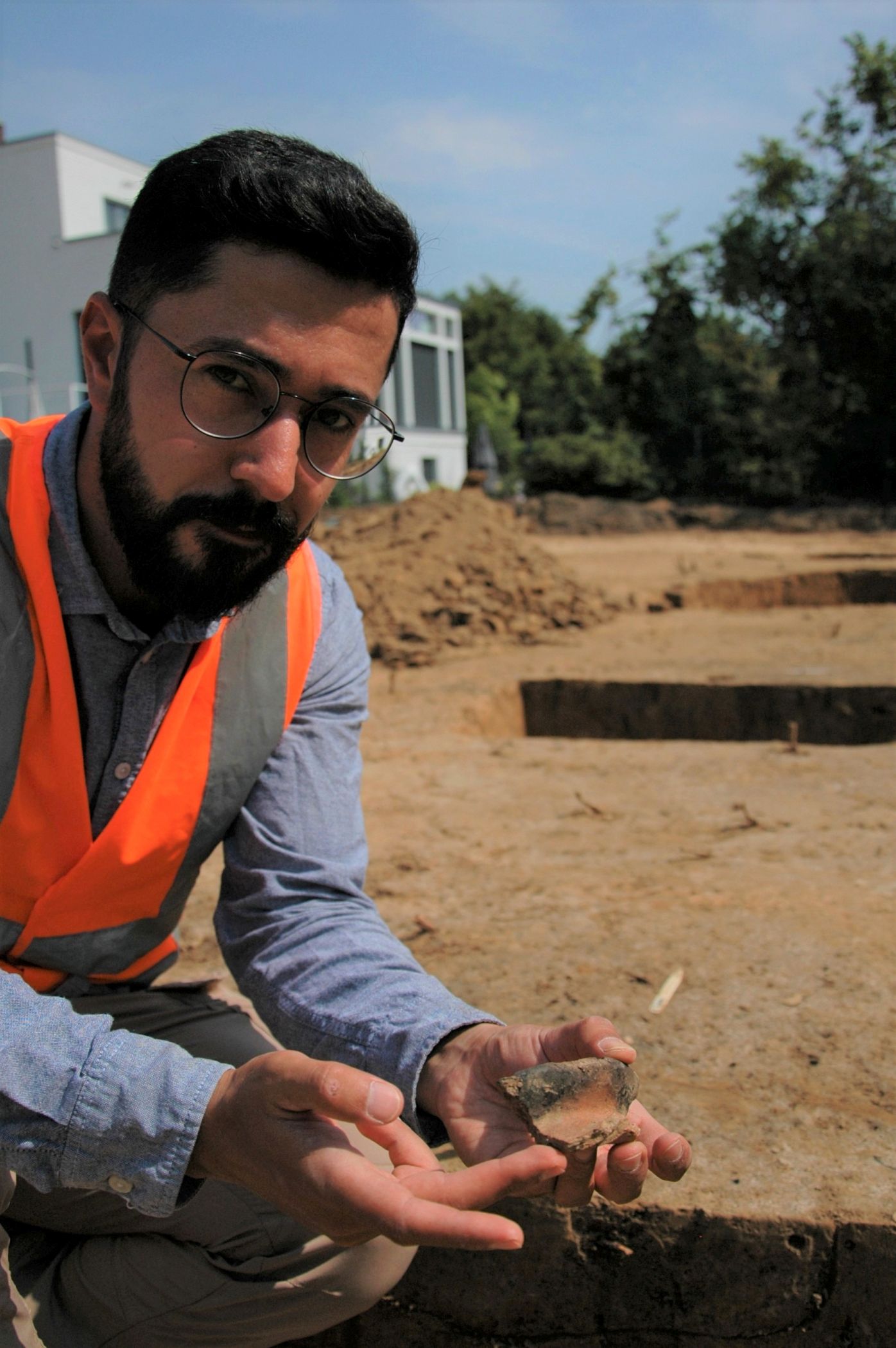 Ein unscheinbarer Fund ist ausgesprochen wichtig für die Stadtgeschichte Werthers: Grabungsleiter Hisham Nabo präsentiert die Scherbe eines Kugeltopfes, die einen Hinweis zur zeitlichen Einordnung des Gebäudes in das 10./11. Jahrhundert gibt.<br>Foto: LWL/S. Düvel