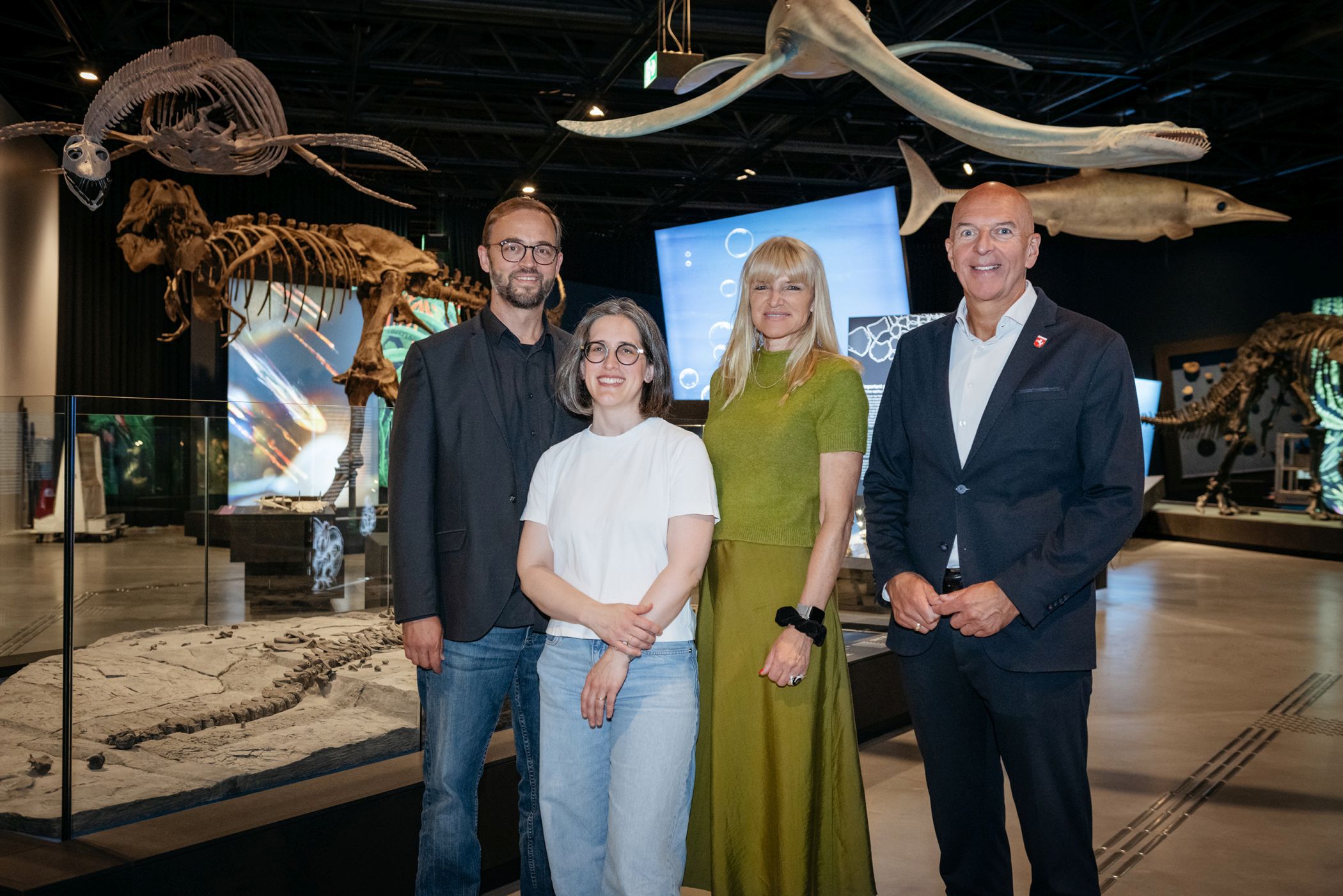 von rechts: Dr. Georg Lunemann, der Direktor des LWL, und LWL-Kulturdezernentin Dr. Barbara Rüschoff-Parzinger, zusammen mit Kuratorin Lisa Wong und Museumsdirektor Prof. Dr. Jan Ole Kriegs vor den beindruckenden Westphaliasaurus-Fossilien, Skeletten und Modellen.<br>Foto: LWL/Steinweg