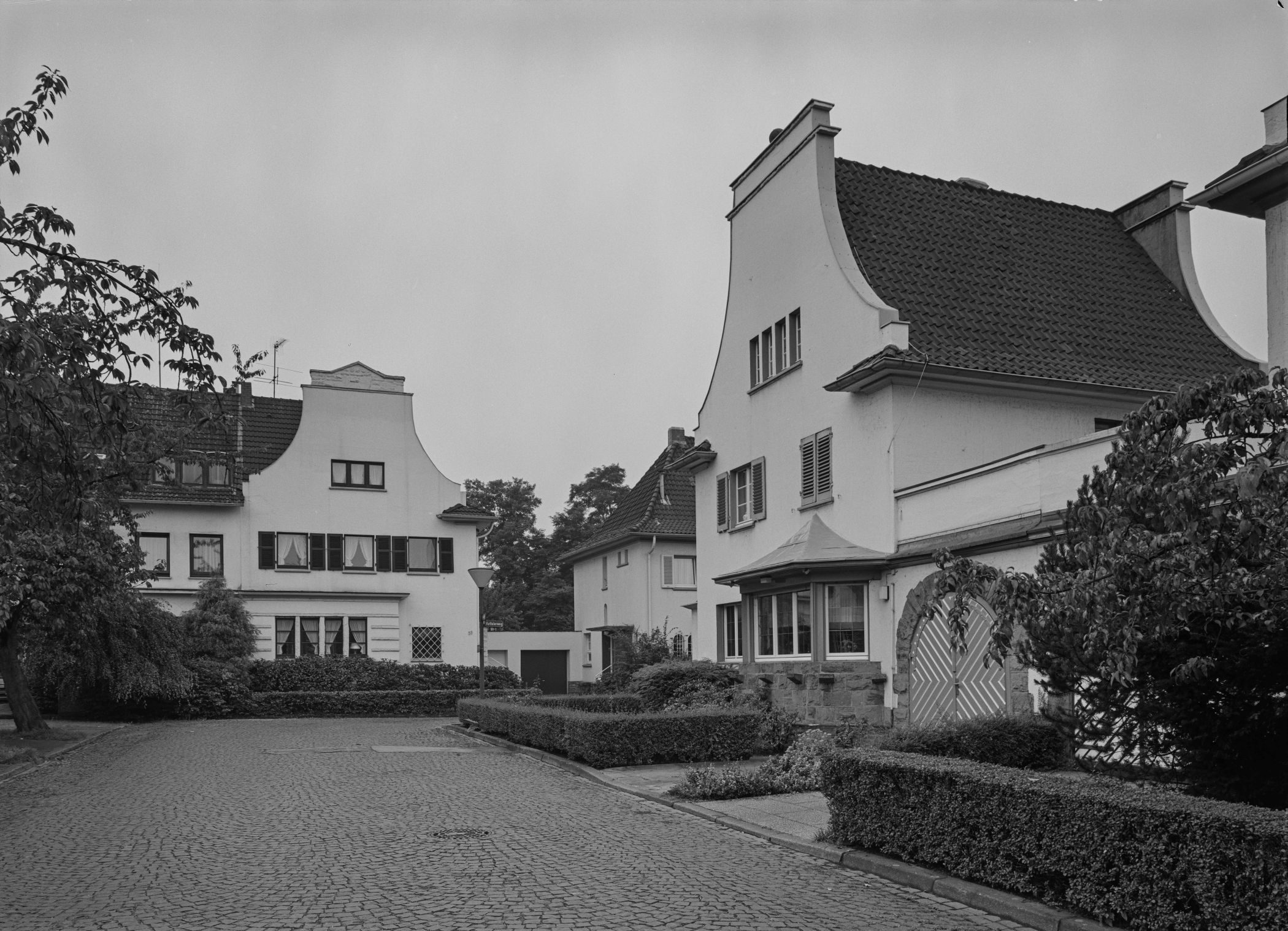 Der Sichtbezug von der Grabbestraße auf den Kettlerweg ist über die Denkmalbereichssatzung geschützt. Hier zu sehen sind die Denkmäler Kettelerweg 20 und 55, beide 1927 von D. und K. Schulze, hier in den Jahren 1991 und 2025.<br>Foto:LWL/Hedwig Nieland