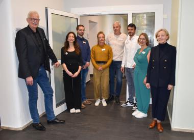 Die Betriebsleitung der LWL-Klinik Münster, mit dem Kaufmännischen Direktor Thomas Voß (ganz l.), Pflegedirektor Michael Lison (4.v.r.) und der Ärztlichen Direktorin Prof. Dr. Patzricia Ohrmann (ganz r.), und das Team der Station 17.2 freuen sich über die Öffnung der vormals geschützt geführten Suchtstation.<br>Foto: LWL/Kaufhold