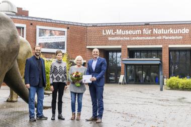 Dr. Georg Lunemann (rechts) und Dr. Jan Ole Kriegs überraschten die 300.000 Besucherinnen des LWL-Museums für Naturkunde Ingrid Neugebauer (2. von rechts) und Karin Schulte.<br>Foto: LWL/Hanna Neander