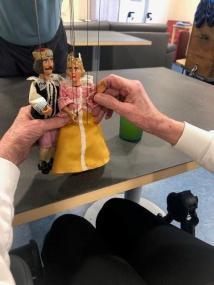 Eine Bewohnerin des LWL-Pflegezentrums erkundet den Aufbau einer Marionette.<br>Foto: LWL