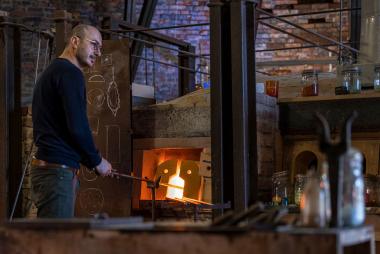 Glasdesigner Rejwan Toplu bei der Arbeit in der Produktion des LWL-Museums Glashütte Gernheim.<br>Foto: LWL / Harms. 