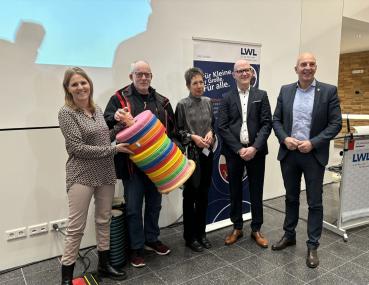 Dr. Georg Lunemann, der Direktor des LWL (r.) übergibt an die Schulpflegschaftsvorsitzenden Beate Ziehe (v.l.) und Roland Stange und den beiden Schulleitungen Ulrike Witte und Torsten Dittrich das Einweihungsgeschenk bunte Sitzkissen. <br>Foto: LWL