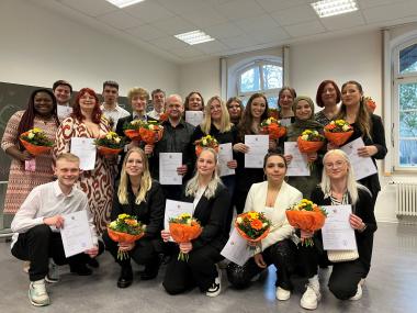 Die frisch gebackenen Pflegefachfrauen und -männer mit ihren Zeugnissen und Blumensträußen.<br>Foto: LWL/Herstell