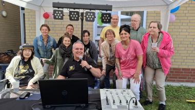 Das LWL-Pflegezentrum Dortmund &quot;Am Apfelbach&quot; hat die Bewohnerinnen und Bewohner zum Sommerfest geladen. Über die gut besuchte Feier freute sich unter anderem die Pflegedienstleitung Christin Orgis (hinterste Reihe, 2.v.l.). DJ &quot;Atommic&quot; (Mitte) sorgte mit Musik für gute Stimmung.&lt;br&gt;Bild: LWL 