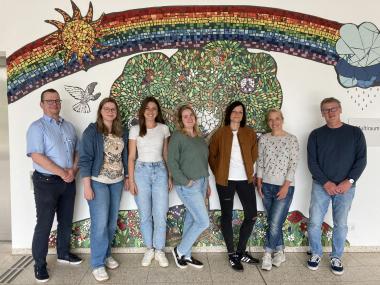 Freuen sich schon auf das bunte Ferienprogramm für Kinder von Mitarbeitenden (v.l.): Ralf Quade (stellvertretender Pflegedirektor LWL-Uniklinik Hamm), die Kolleginnen aus dem Erziehungsdienst: Johanna Lütkehaus, Cindy Koch, Melanie Zydra und Julia Steinke, Rebecca Pruß (Verwaltungsangestellte in der Personalabteilung und Initiatorin des Sommerferien-Programms) sowie Jürgen Beckmann-Hotte (Schulleiter der Klinikschule auf dem Klinikgelände).&lt;br&gt;Foto: LWL/Suilmann 