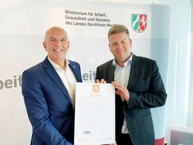Übergabe der "Charta zur Vereinbarkeit von Beruf & Pflege" an den Direktor des LWL, Dr. Georg Lunemann (l.), durch NRW-Staatssekretär Matthias Heidmeier.<br>Foto: NRW-Gesundheitsministerium