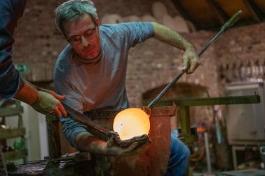 Die Kunst der manuellen Glasfertigung wurde zum Immateriellen Erbe der Menschheit ernannt. Lebendig erhalten wird das Handwerk unter anderem von den Glasmacherinnen und Glasmachern - hier im Bild Korbinan Stöckle - im LWL-Museum Glashütte Gernheim.<br>Foto: LWL / Peter Hübbe