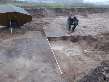 Grabungsleiter Sven Knippschild untersucht ein 2.000 Jahre altes Grubenhaus bei nasskaltem Novemberwetter.<br>Foto: LWL-AfW/S. Spiong