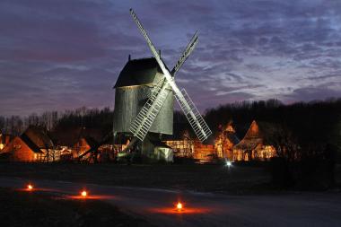 Die Beleuchtung zum Museumsadvent bietet neue Perspektiven auf die historischen Gebäude, wie die Bockwindmühle vor dem Paderborner Dorf.<br>Foto: LWL/ Robin Jähne