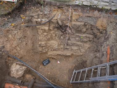 Blick auf die Überreste der Treppe in den ehemaligen Burggraben oder jüngeren Keller. In der Mitte oben deutet sich der Durchgang in die Vorburg an.<br>Foto: EggensteinExca/Marianne Moser