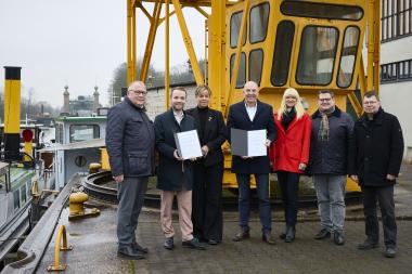 NRW-Wirtschaftsministerin Mona Neubaur (3.v.l.) übergab die Förderbescheide im LWL-Museum Schiffshebewerk Henrichenburg an Dr. Georg Lunemann, der Direktor des LWL (Mitte) und Bürgermeister Marcel Mittelbach (2.v.l.). Außerdem im Bild: Josef Hovenjürgen, Parl. Staatssekretär im NRW-Heimatministerium (l.), IGA-Geschäftsführer Horst Fischer (v.r.), LWL-Baudezernent Urs Frigger und LWL-Kulturdezernentin Dr. Barbara Rüschoff-Parzinger.<br>Foto: LWL / Julia Gehrmann 