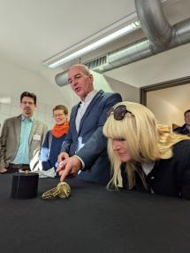 Das römische Miniatur-Dosenschloss, kleiner als eine Ein-Euro-Münze, und seine vergrößerte Rekonstruktion sorgen für große Begeisterung bei Dr. Georg Lunemann, dem Direktor des LWL, und LWL-Kulturdezernentin Dr. Barbara Rüschoff-Parzinger. Im Hintergrund Dr. Ulrich Lehmann vom Sachgebiet Sondengehen und Magnetangeln und  Dr. Julia Hallenkamp-Lumpe von der Außenstelle Bielefeld, LWL-Archäologie für Westfalen.<br>Foto: LWL/Julia Großekathöfer
